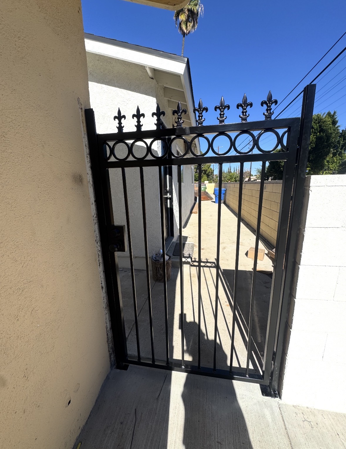 Black wrought iron walk gate with finial detail