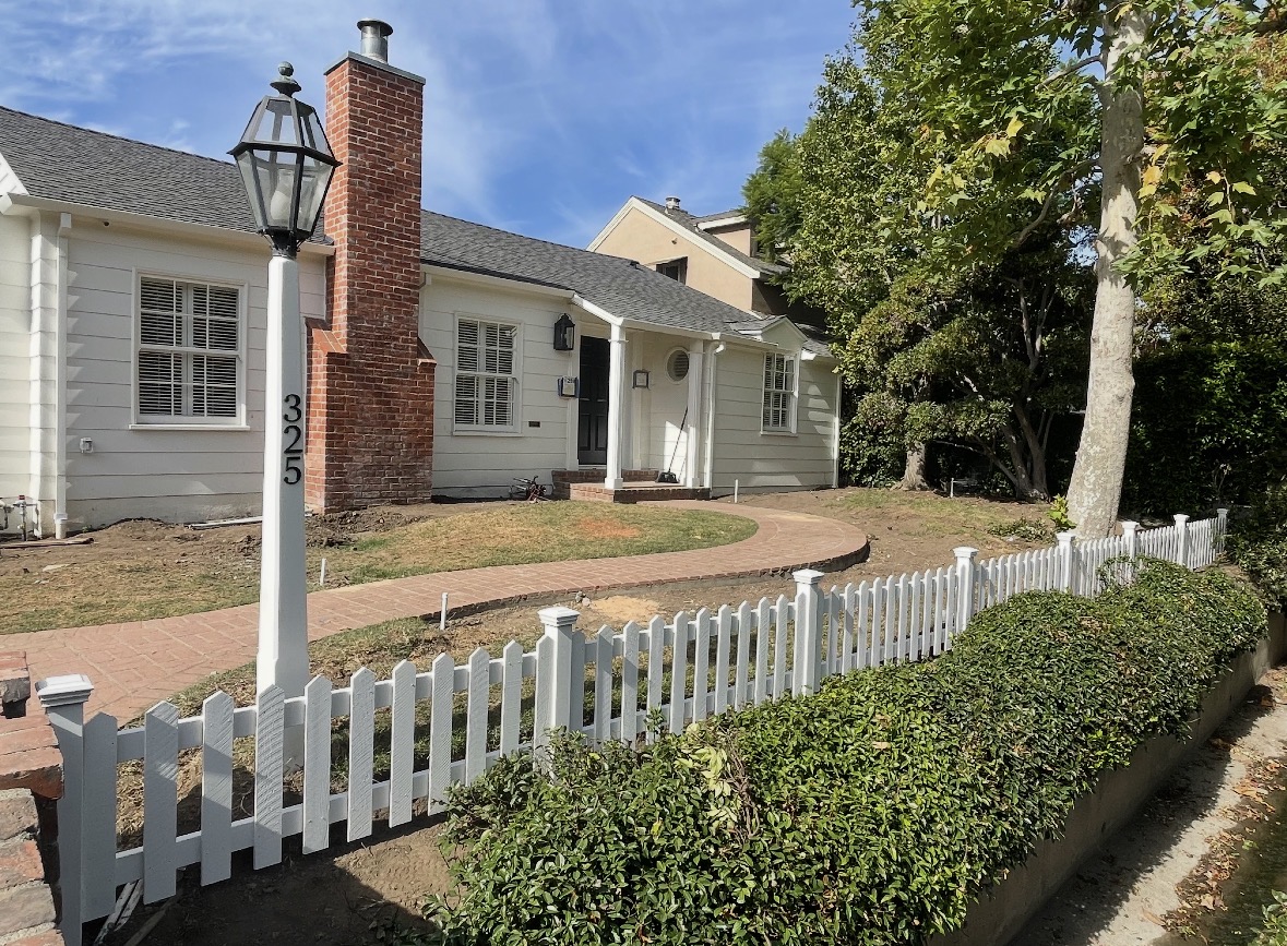 White picket fence in front of a craftsman home