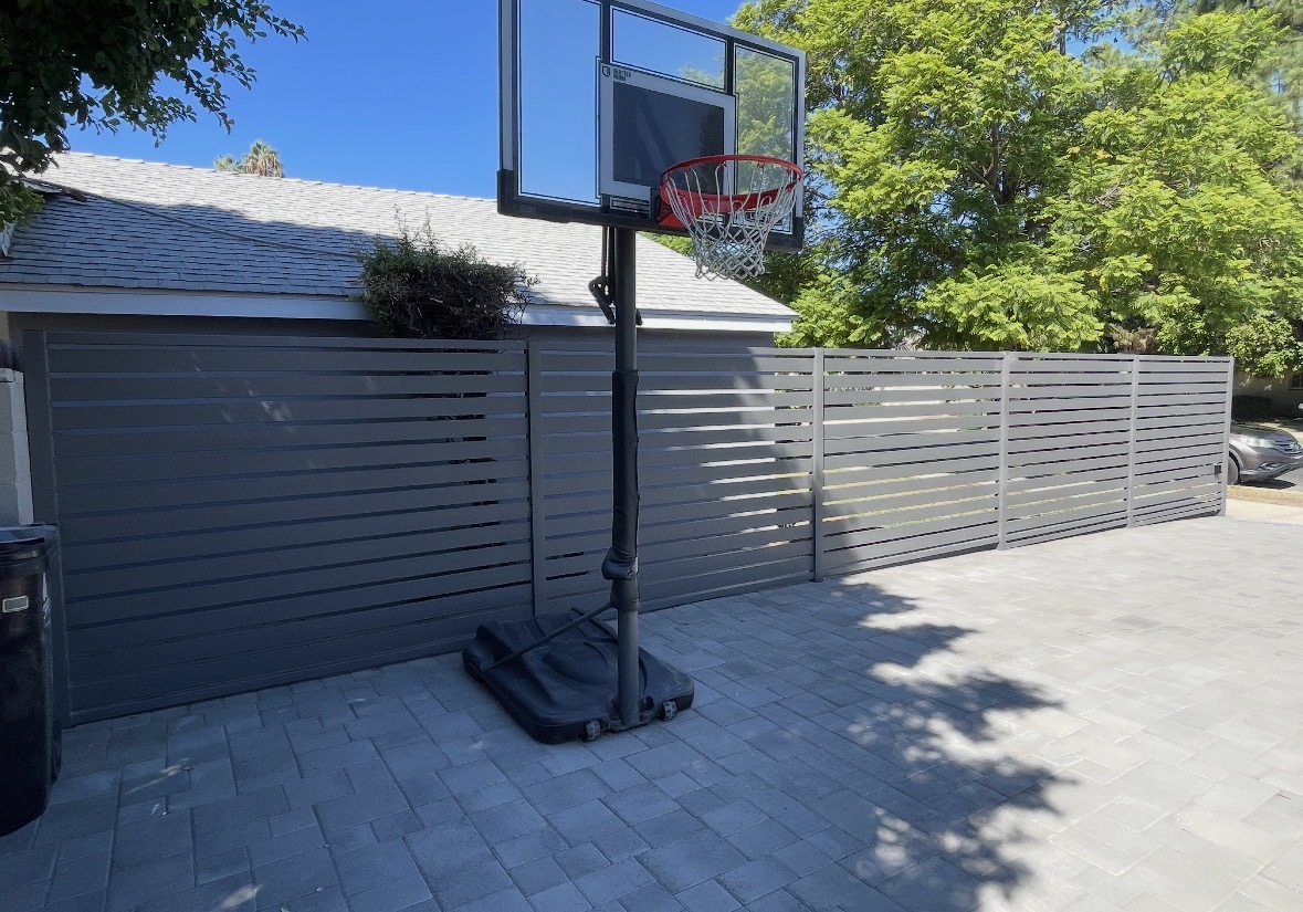 Grey horizontal slat privacy fence around a patio
