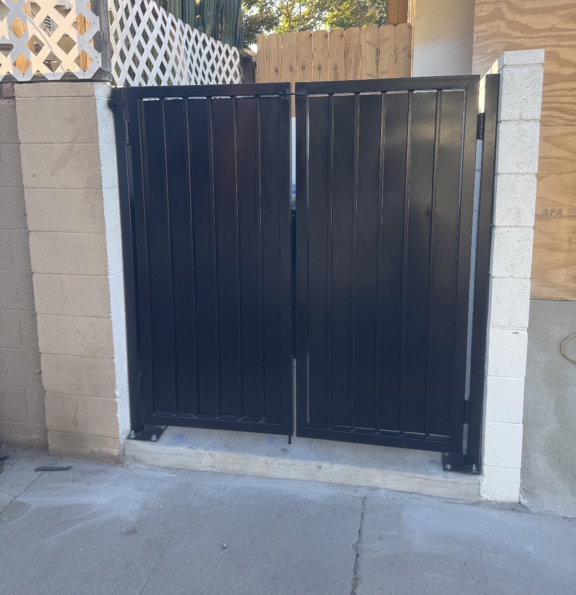 Black metal double gate between white pillars