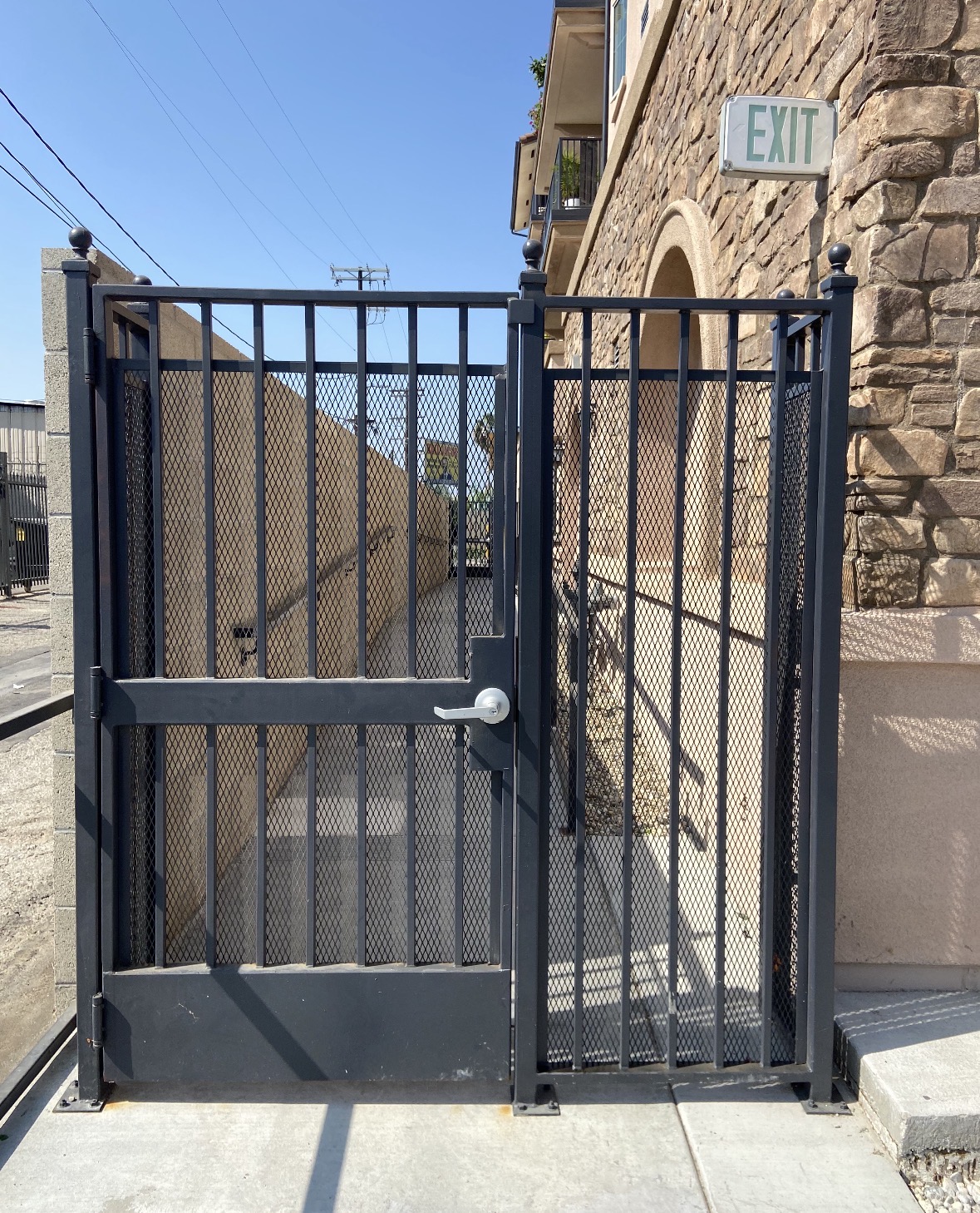 Black iron mesh pedestrian gate at a building exit