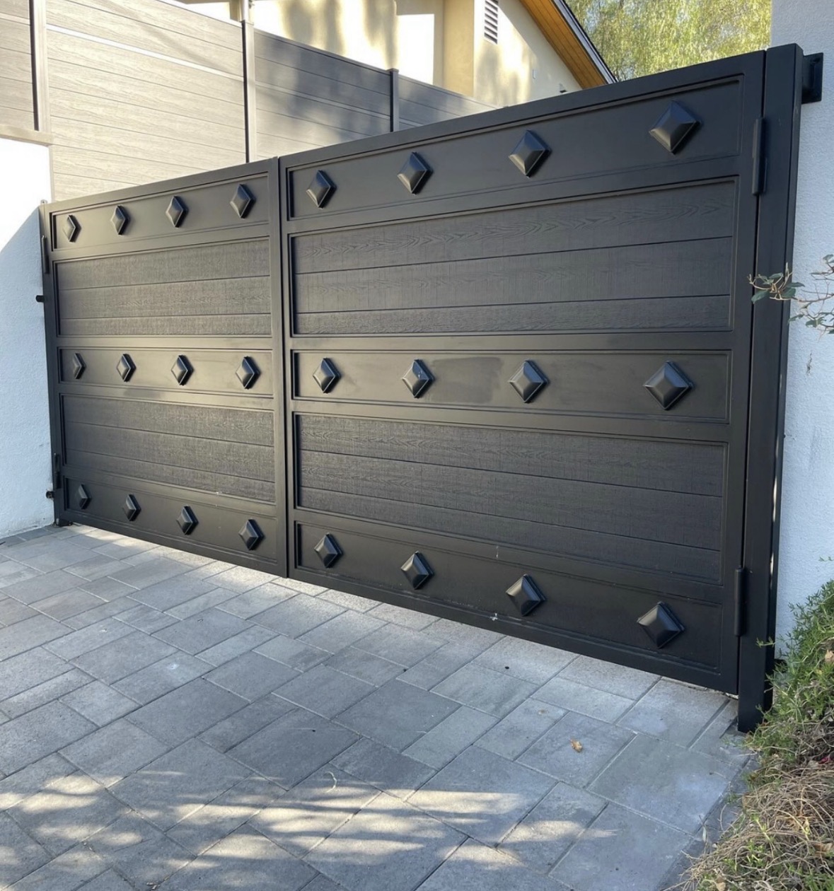 Black double driveway gate with square accents