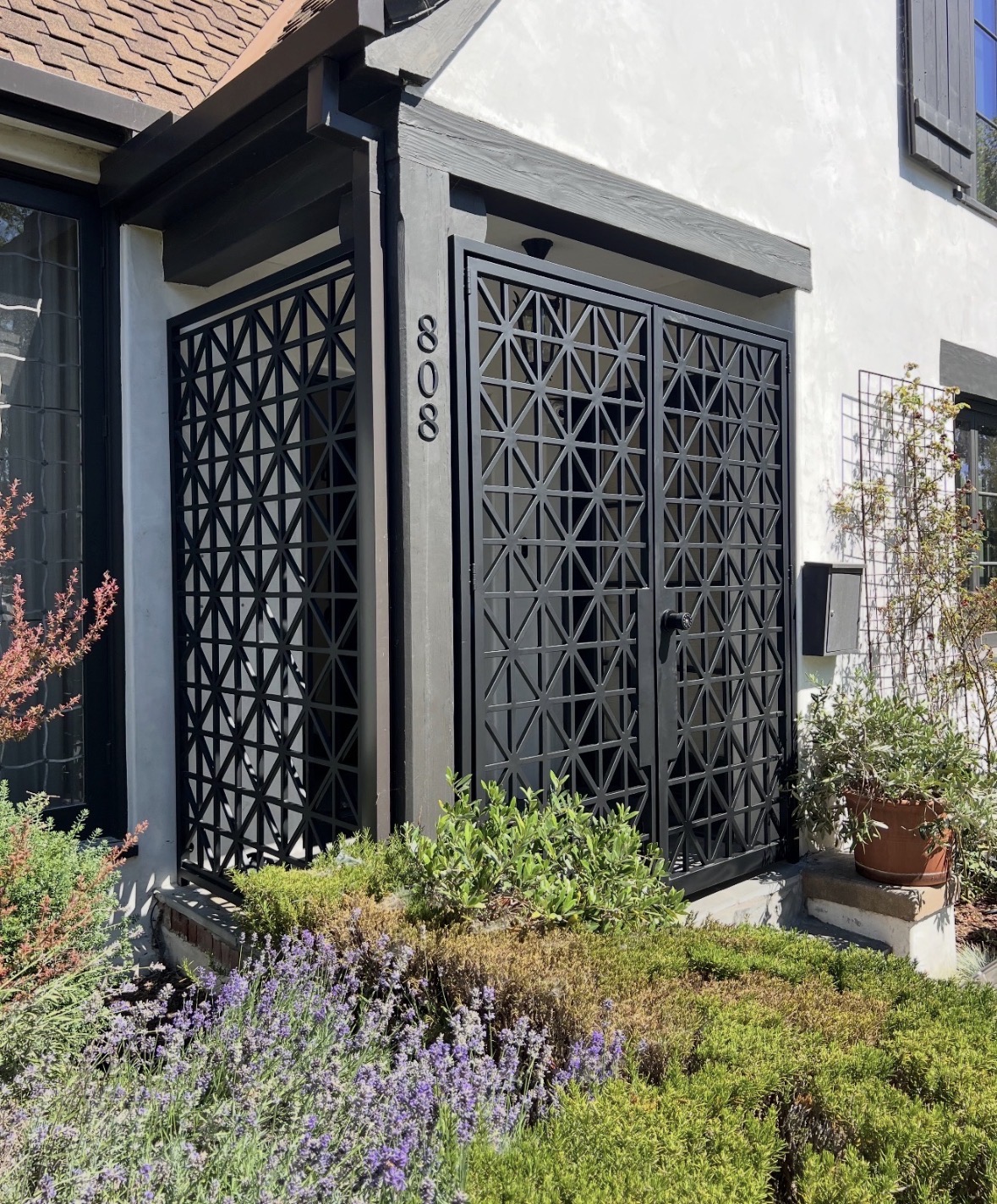 Black geometric entry gate in a landscaped courtyard