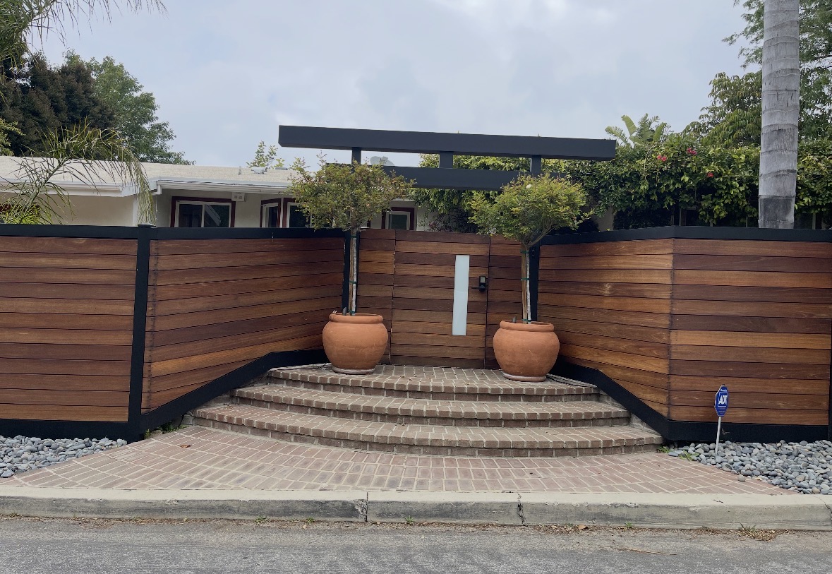 Mahogany entry gate with a black overhead trellis