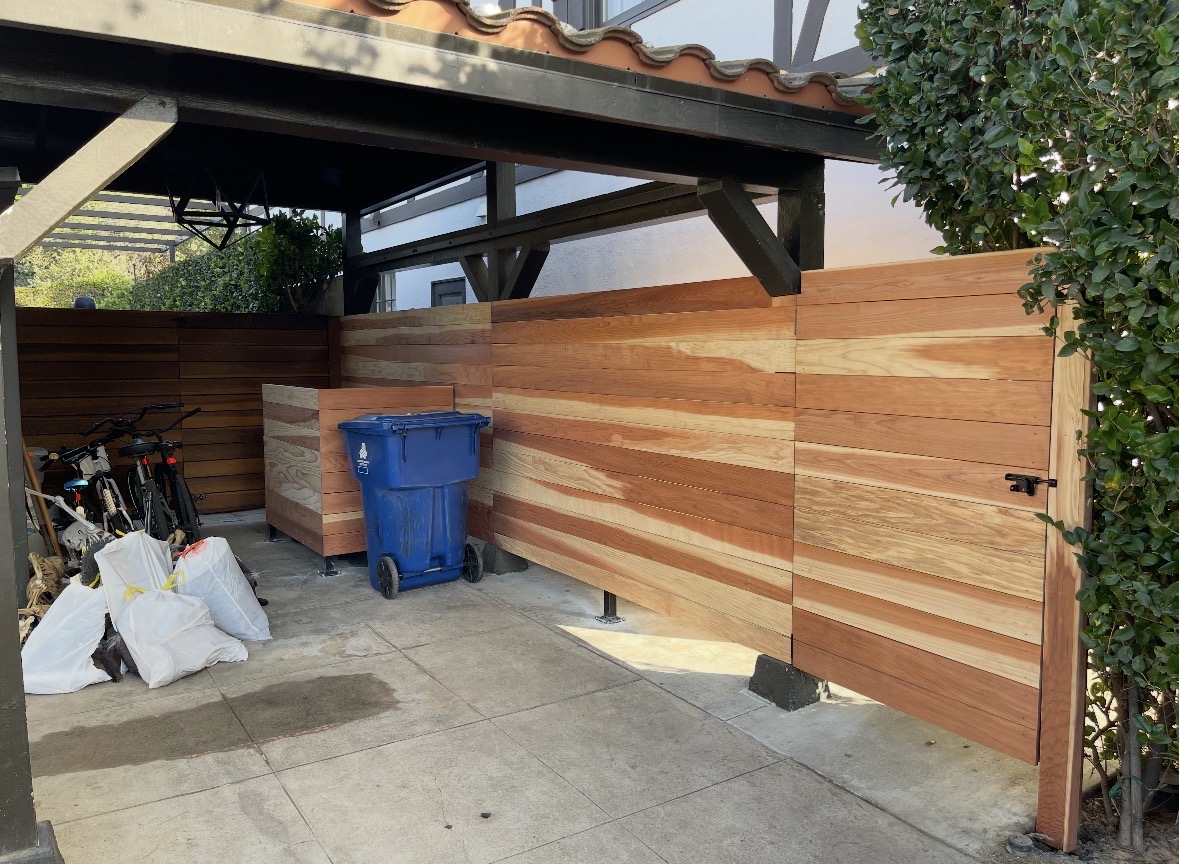 Mixed hardwood fence and gate in a covered carport