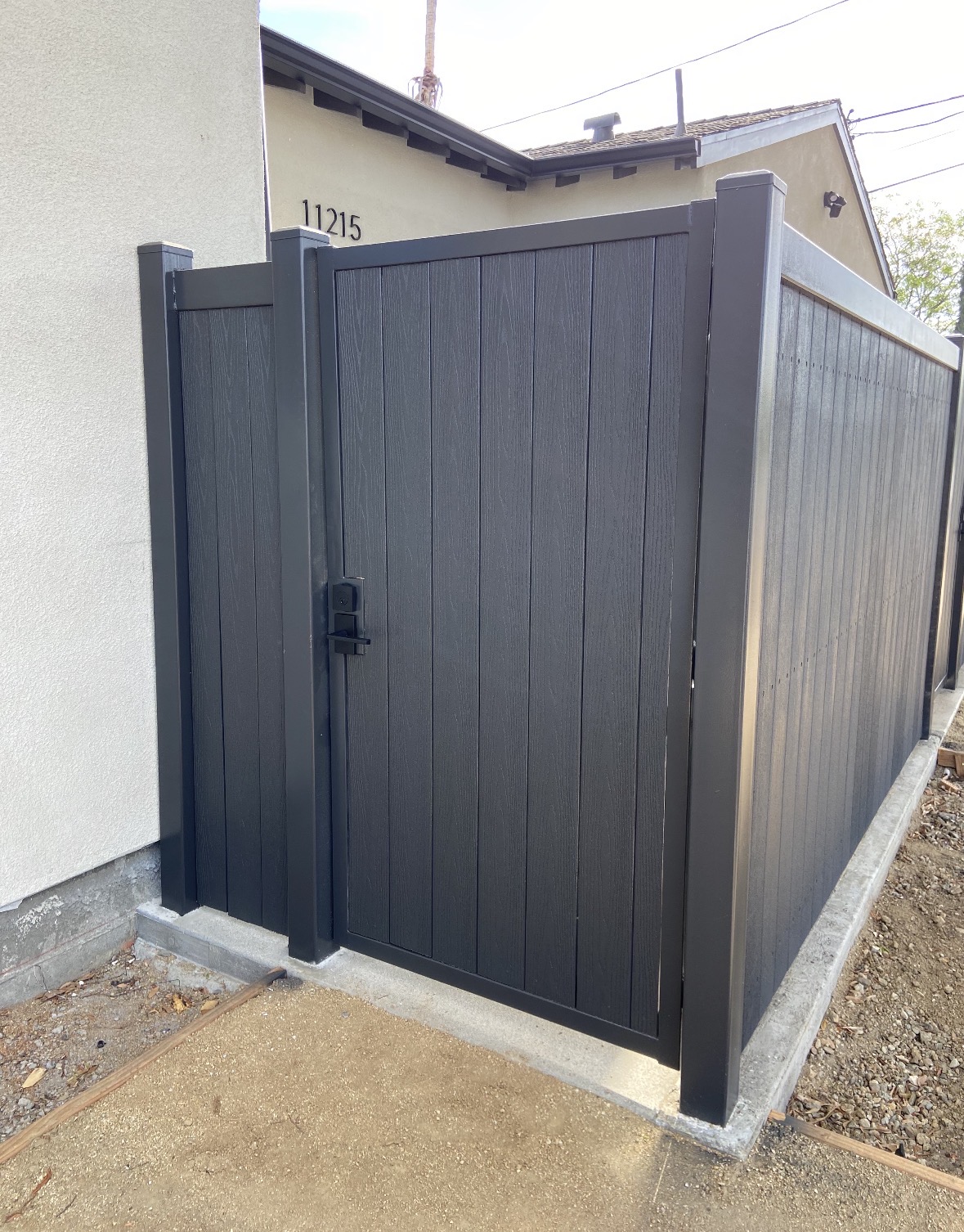 Dark vertical vinyl fence and matching pedestrian gate