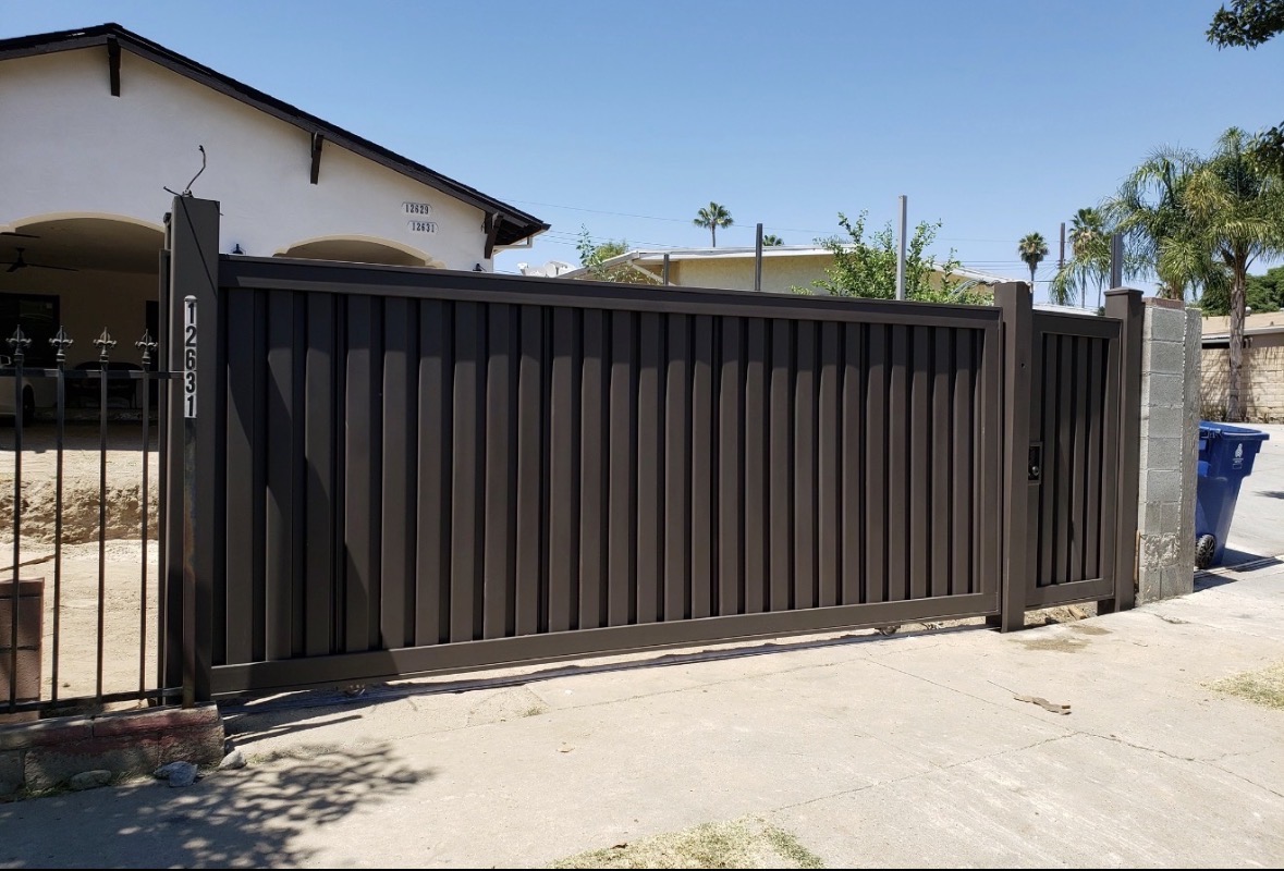 Bronze sliding driveway gate in front of a home
