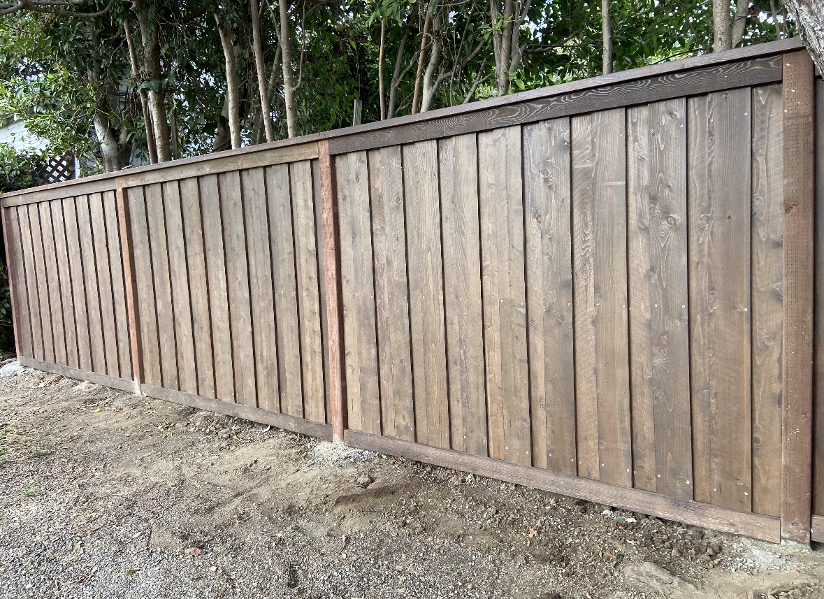 Wood privacy fence beneath garden trees