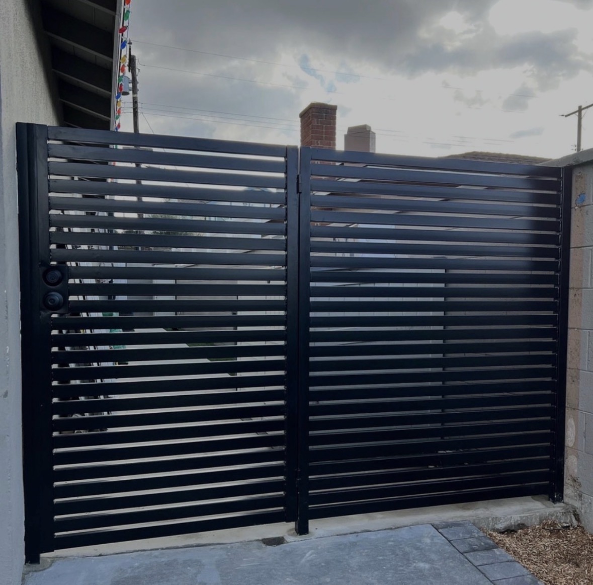 Black horizontal slat double gate with a privacy screen