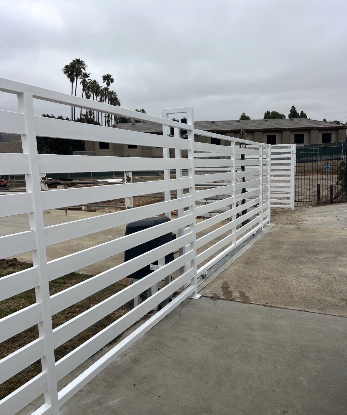 White horizontal slat sliding driveway gate