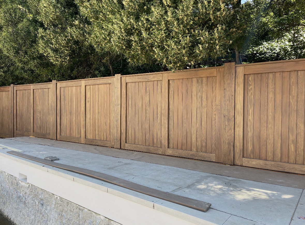 Wood privacy gates along a raised concrete patio