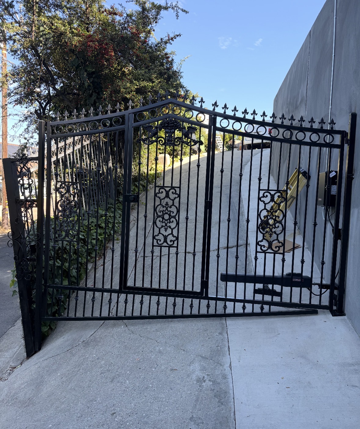 Ornamental black iron driveway gate with scrollwork